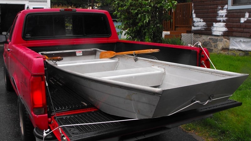 A small jon boat johnboat in a red pickup truck